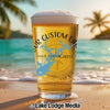 Beer glass with "YOUR CUSTOM IMAGE" text and compass graphic on a beach.