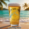 Beer glass with "Chatt's Bar Lake" text and compass graphic on a beach.