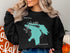 Black sweatshirt with "Beautiful Lake Huron Michigan" map graphic and compass rose.