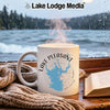 White mug with Lake Pleasant Arizona design sits by a window with a book and scarf.