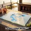 Glass cutting board printed with a blue map of Lake Lahontan and compass design on a wooden table.