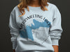 Light blue sweatshirt with Merrymeeting Lake New Hampshire map and compass design.