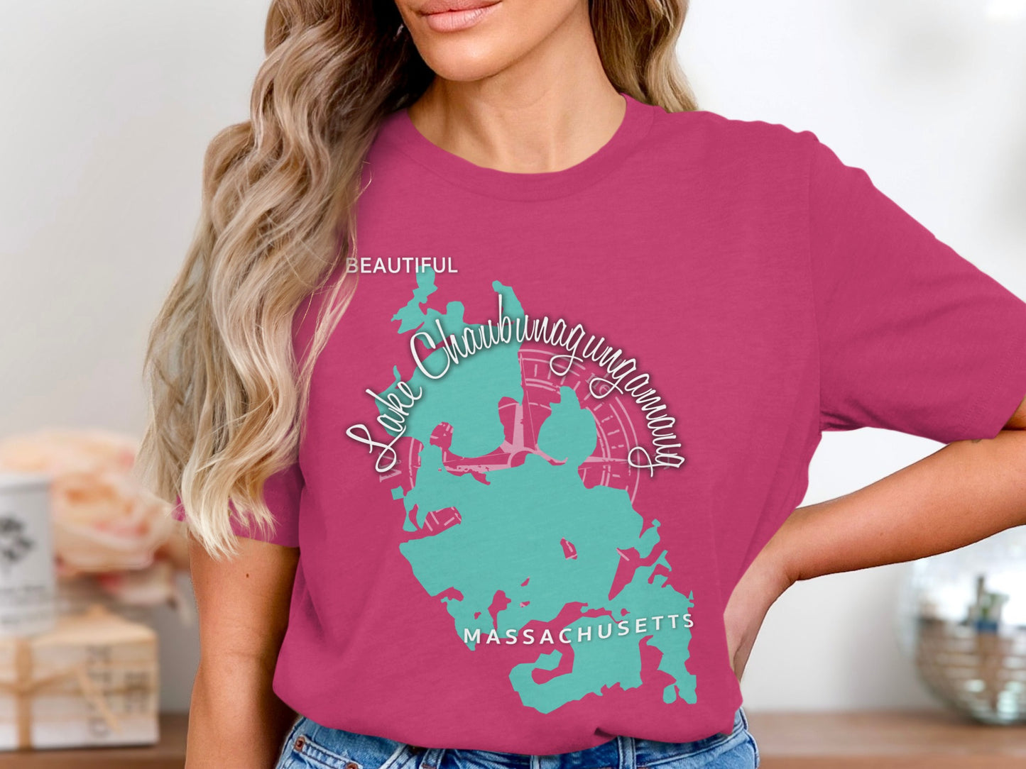 Woman wearing a pink t-shirt with a teal map of Lake Chaubunagungamaug, Massachusetts.