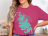 Woman wearing a pink t-shirt with a teal map of Lake Chaubunagungamaug, Massachusetts.