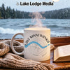 White mug with "Lake Minnewanka Banff" design on a table by a rainy window.