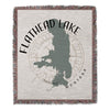 Woven blanket with Flathead Lake Montana map silhouette and compass rose design.