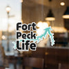 "Fort Peck Life" text with turquoise lake graphic on reflective glass.