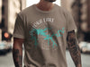Taupe t-shirt with Patoka Lake Indiana compass graphic and arm tattoos.