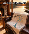 Woven blanket with Lake Wylie map and compass design on a sofa.