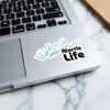 Norris Life sticker with lake outline on laptop keyboard.
