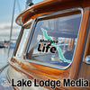 Turquoise lake outline sticker with "Maligne Life" text on boat window, "Lake Lodge Media" logo.