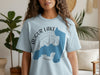 Light blue t-shirt with Augur Lake New York map and compass graphic.