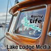 Sticker on boat window with "Rainy Life" text and lake outline, "Lake Lodge Media" logo.