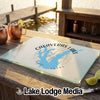 A glass cutting board featuring a blue map of Calaveras Lake sits on a wooden dock.