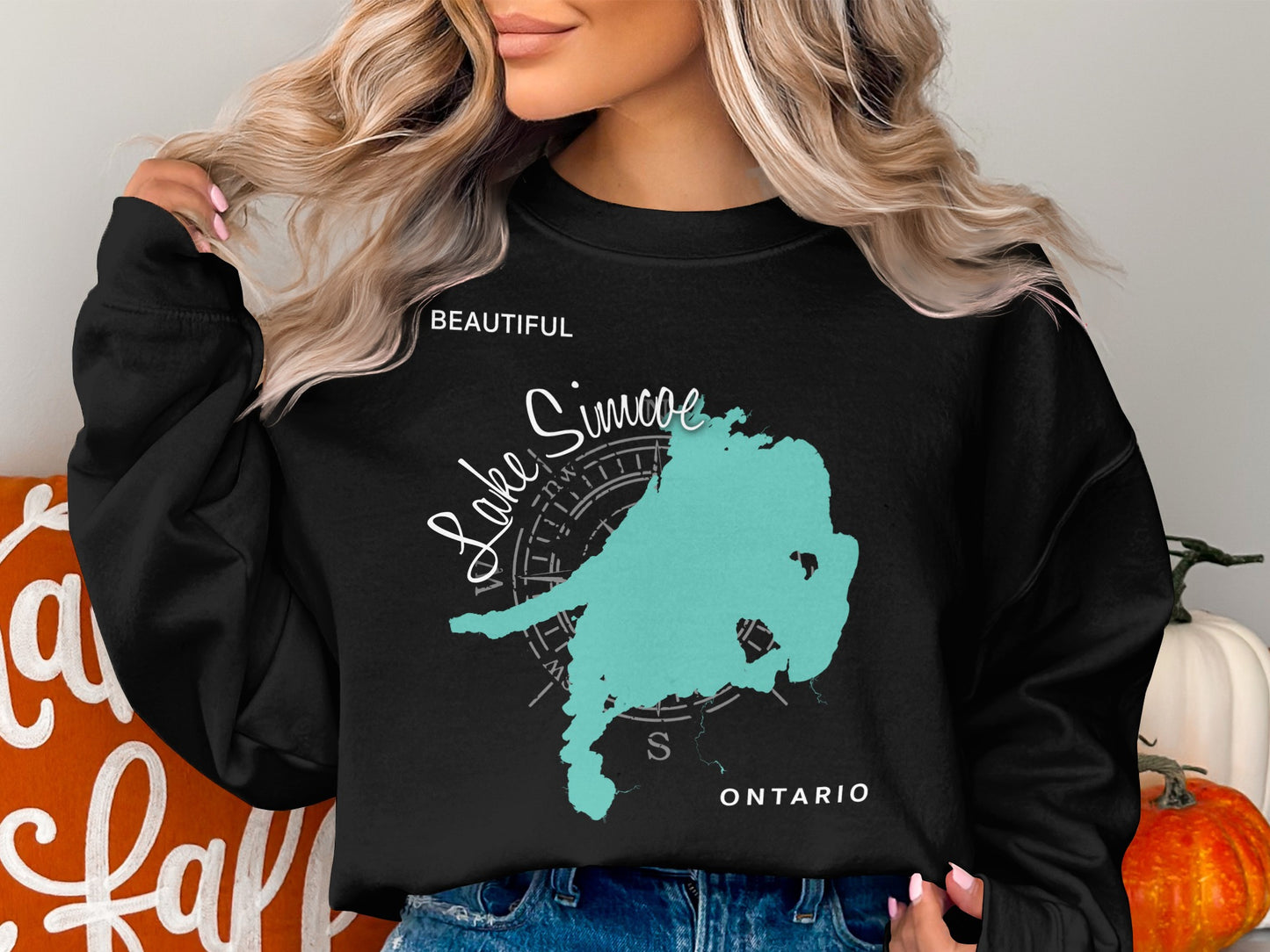 Black sweatshirt with turquoise Lake Simcoe map outline and "Beautiful Lake Simcoe Ontario" text.
