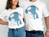 White t-shirts feature blue map outline of Yellowstone Lake and compass.