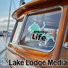 Granby Life decal on a wooden boat window and "Lake Lodge Media" logo.