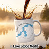 White mug with Little Saint Germain Lake map and compass design, coffee pouring in.