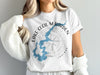 White t-shirt with blue Lake Cecil M Harden map and compass design.