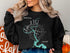 Black sweatshirt with "Beautiful Lake LBJ Texas" and compass on dark background.