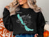 Black sweatshirt with a Chautauqua Lake, NY map and compass graphic.
