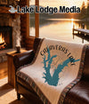 Woven blanket with Calaveras Lake map design on a leather couch.