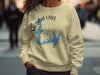Light yellow crewneck sweatshirt with Medina Lake Texas map and compass graphic.