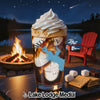 Dessert drink in glass with whipped cream, campfire, lake, and s'mores ingredients.