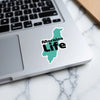 Turquoise Moraine Life sticker on a laptop keyboard with a marble surface.