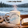 White mug with Old Hickory Lake map design on windowsill with book and scarf.