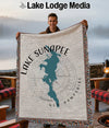 Man holding a woven blanket featuring a map of Lake Sunapee, New Hampshire.