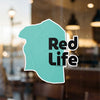 Teal sticker with black text "Red Life" on a window