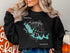 Black sweatshirt with a teal map of Lake Tobesofkee, Georgia and compass.
