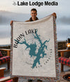 Man holds Badin Lake, North Carolina map woven blanket with fringed edges.