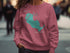 Pink sweatshirt with teal Sandhill Lake Wisconsin graphic and compass rose.