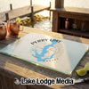 Glass cutting board featuring a Perry Lake, Kansas map design rests on a wooden outdoor bar.