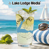 Glass with drink, lime, mint, sunglasses on striped cushion, and sailboat in background.