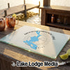 A glass cutting board featuring a blue map of Mooselookmeguntic Lake Maine and a compass design.