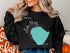 Black sweatshirt with a turquoise outline map of Lake Minnetonka, Minnesota.