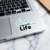 Taylorsville Life sticker design featuring a turquoise outline and black text on a laptop.