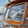 Melton Hill Life sticker on a boat window next to Lake Lodge Media logo.