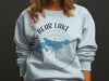 Light blue sweatshirt with "Big Bear Lake California" text and a blue lake shape over a compass.