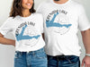 White t-shirts with blue Grenada Lake map graphic and compass.