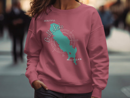 Pink sweatshirt with teal compass graphic of Gull Lake, Michigan.