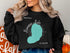 Black sweatshirt with turquoise "Newnan Lake Florida" map graphic and compass rose.