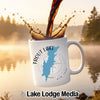 White mug with "Trout Lake New York" map design and compass graphic.