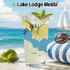 Glass with drink, limes, mint, and sunglasses on a striped pillow.