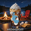 Glass of iced coffee with whipped cream, campfire, lake, and s'mores ingredients.