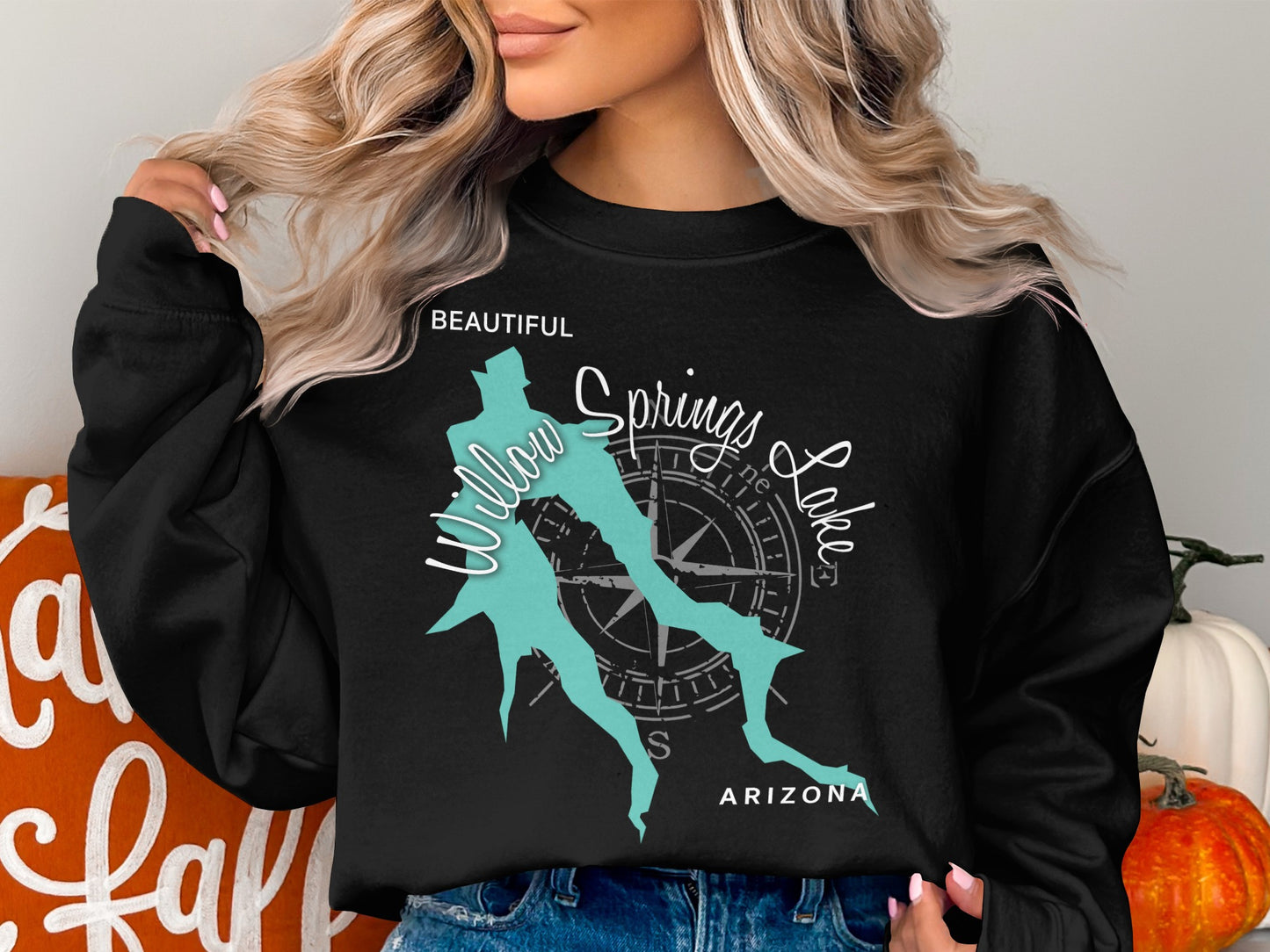 Black crewneck sweatshirt with a teal map outline and compass rose.
