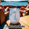 A white wine tumbler featuring a Lake Conroe Texas map graphic sits on a wooden table aboard a boat with two women lounging in the blurred background.